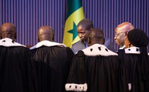 Faye is congratulated by judges from the Constitutional Council. [Jerome Favre/EPA]